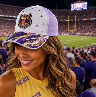 Woman wearing a LSU Tigers cap with pearls at a football game