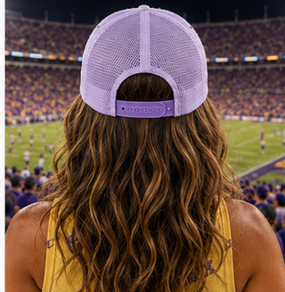 Woman wearing a LSU Tigers cap and yellow shirt at a football game
