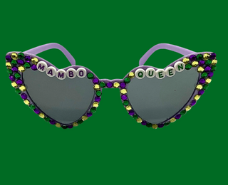 Heart-shaped sunglasses with 'Mambo Queen' text and colorful beads on a white background