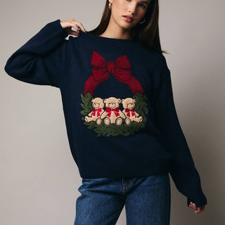 navy blue sweater with a Christmas design featuring teddy bears and a red bow.
